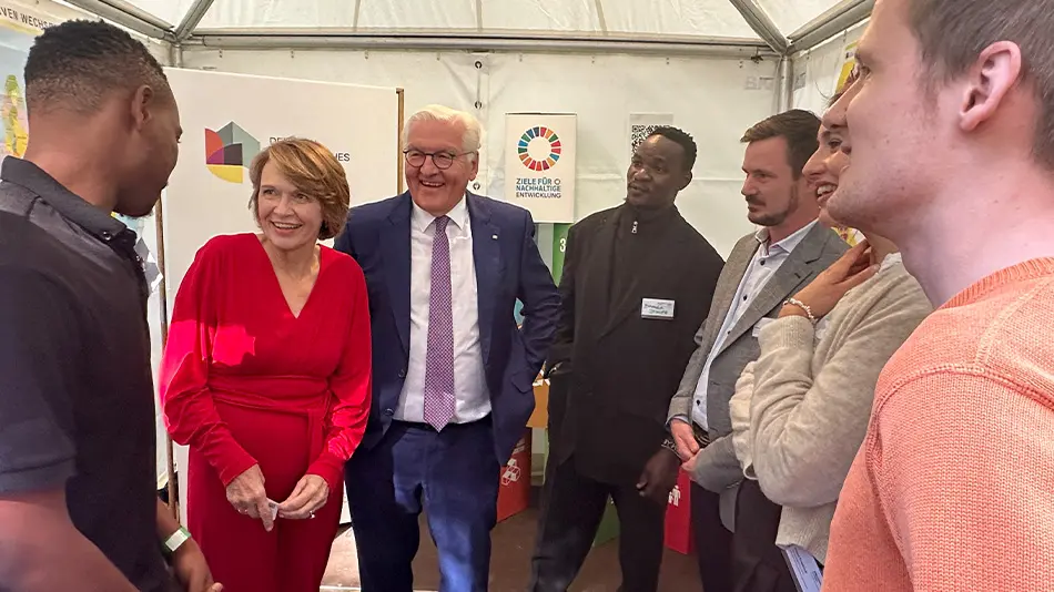 Dieses Bild zeigt sieben Personen im Gespräch im Zelt vom DAJW auf dem Bürgerfest des Bundespräsidenten. Zwei von ihnen sind der Bundespräsident Frank-Walter Steinmeiner und Elke Büdenbender. Die restlichen Personen gehören zum Team vom DAJW.