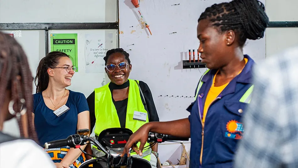 Das Bild zeigt Laurence Bayer und Erica Kusi Amponsah, sowie eine Mitarbeiterin von Solar Taxi in der Werkstatt des Unternehmens.