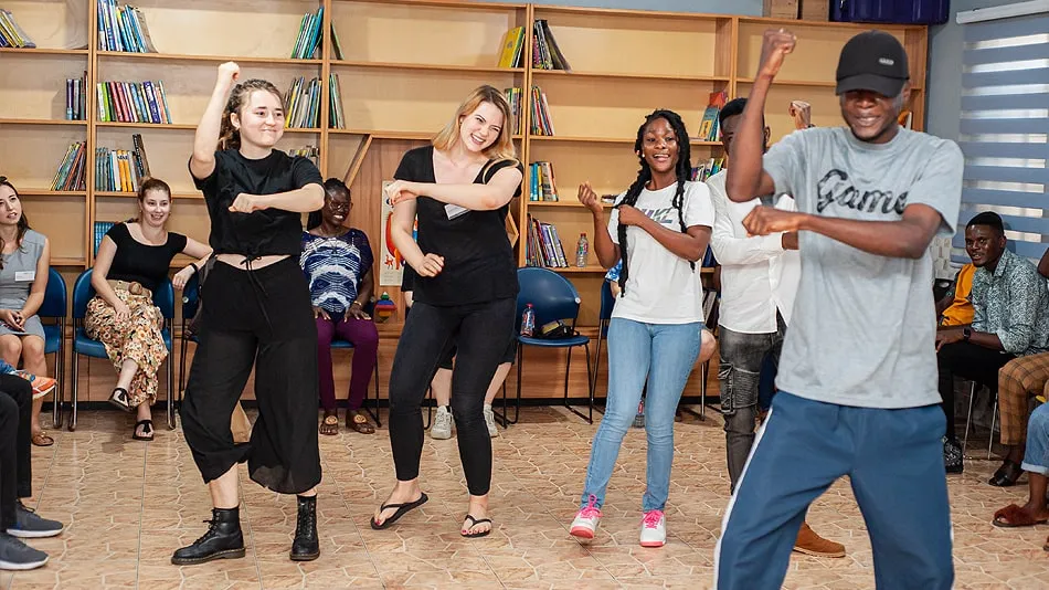 Das Bild zeigt eine Gruppe von Workshop-Teilnehmenden beim Tanzen bei der Organisation DUNK Grassroots. Im Vordergrund sieht man den Tanzlehrer.