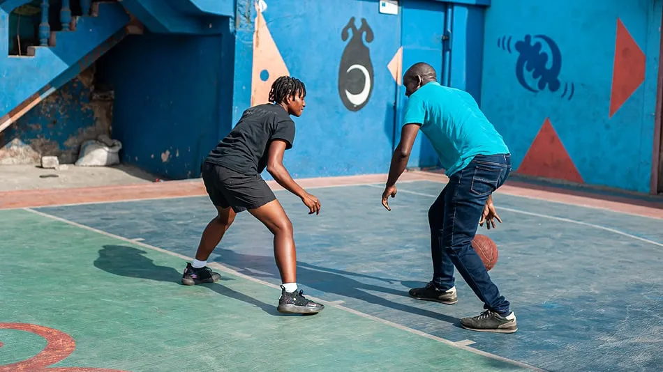 The photo shows two people playing basketball.