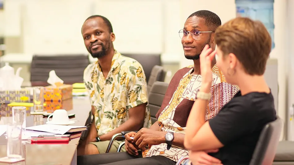 La photo montre trois personnes de l'atelier à la Chambre Allemande de Commerce et d'Industrie à Accra.